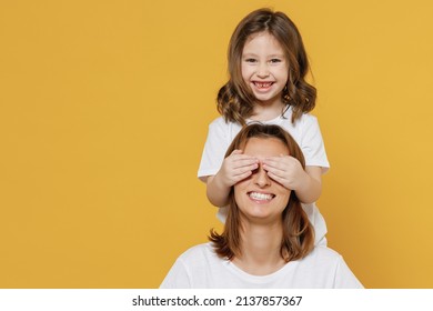 Happy Woman In White T-shirt Have Fun With Cute Child Baby Girl 5-6 Years Old Cover Face. Mommy Little Kid Daughter Isolated On Yellow Orange Color Background Studio. Mother's Day Love Family Concept