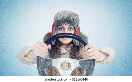 Happy Woman In Winter Clothes With A Steering Wheel, Snow Blizzard. Concept Car Driver