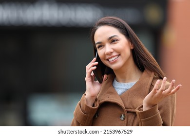 Happy Woman In Winter Making A Phone Call In The Street