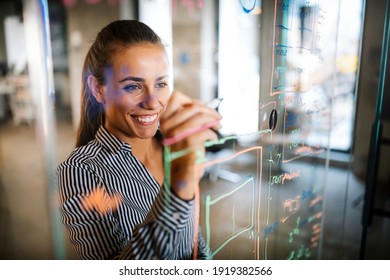 Happy woman working, brainstorming in office. Witting down new ideas - Powered by Shutterstock