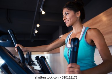 Happy woman workout on exercises machine in fitness gym - Powered by Shutterstock