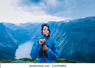 Happy Woman Zip Up Blue Sportive Jacket Before Rain, Relaxing And Smiling In Cliff During Trip Norway. Trolltunga Hiking Route