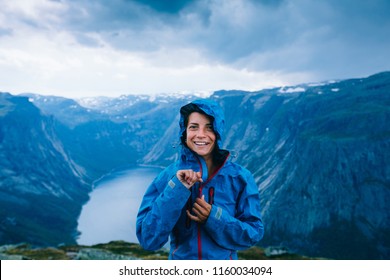 Happy Woman Zip Up Blue Sportive Jacket Before Rain, Get Ready For Adventure And Smiling In Cliff During Trip Norway. Trolltunga Hiking Route