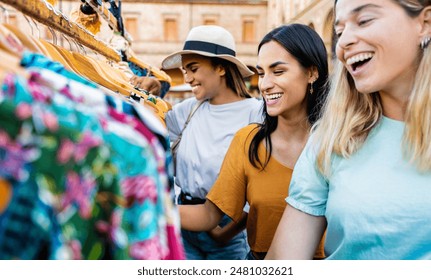 Happy women buying clothes in second hand vintage market in city street - Shopping and retail life style concept - Powered by Shutterstock