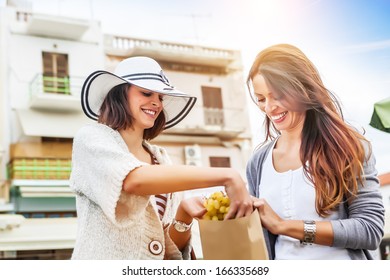 Happy Women Choosing A Fruit Outdoors In The Bio Market