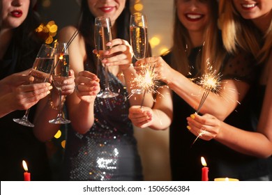 Happy Women With Christmas Sparklers And Glasses Of Champagne At Party