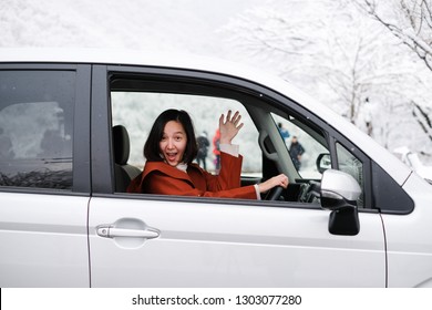 Happy Women Driver Waving Her Hand On Silver Van With Winter Background