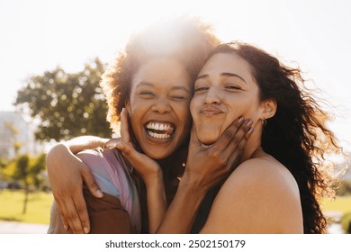 Happy women embracing and enjoying the sunshine in an outdoor setting, capturing the essence of best friends. Girlfriends being silly together. Fun portrait of best friends looking at camera. - Powered by Shutterstock