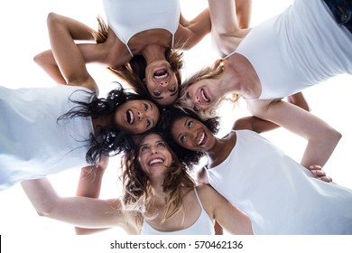 Happy women forming a huddle against the sky