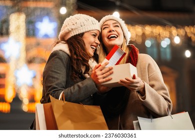 Happy women friends exchanging christmas present. Happiness people friend shopping xmas concept - Powered by Shutterstock