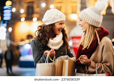 Happy women friends having fun and shopping at Christmas. Sale xmas people happiness concept - Powered by Shutterstock