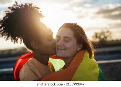 Happy Women Gay Couple Kissing And Wearing Rainbow Flag Outdoor - Love And Lesbian Concept - Soft Focus On Right Girl Face