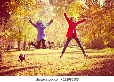 happy women jumping outside at autumn fall 