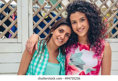 Happy Women Looking At Camera Over Garden Fence