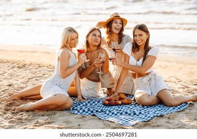 Happy women with wine glasses at beach picnic. Celebration, friends, bachelorette party and holidays concept. Hen party. - Powered by Shutterstock