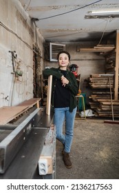 Happy Woodworker Looking At Camera Near Plank And Jointer Machine