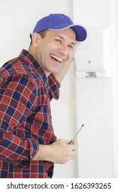 A Happy Worker Checking Thermostat