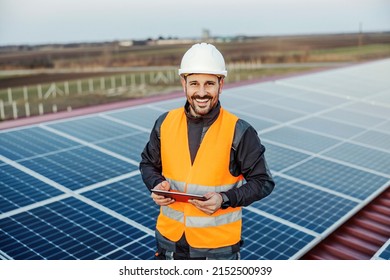 A happy worker testing solar panels with tablet. - Shutterstock ID 2152500939