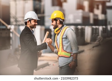 Happy Workers At Construction Site, Young Civil Engineer Manager And Architects Handshaking At Construction Site And Looking To Next Construction Phase  , Cooperation Teamwork Concept.