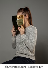 Happy world book day 2020, be safe and read to become someone else - woman covering face with book in mask while reading on grey studio background. Celebrating, education, art, protection concept. - Shutterstock ID 1688595439