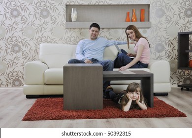 Happy Youg Family Relaxing In Modern Livingroom At Home