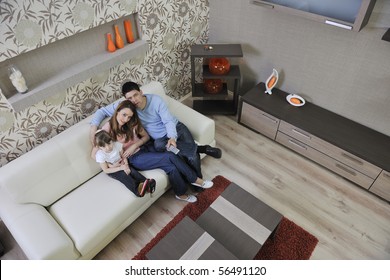 Happy Youg Family Relaxing In Modern Livingroom At Home