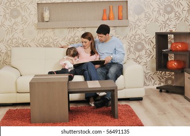 Happy Youg Family Relaxing In Modern Livingroom At Home