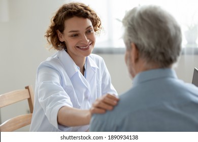 Happy young 30s beautiful physician doctor nurse supporting elderly mature retired patient, sharing good news about health test results, feeling satisfied with disease treatment at checkup meeting. - Powered by Shutterstock