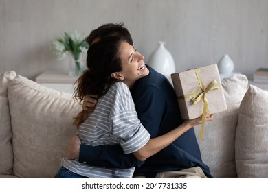 Happy young 30s latina woman embracing loving husband, feeling thankful for getting present in wrapped gift box, celebrating happy birthday or marriage anniversary, international women s day. - Shutterstock ID 2047731335