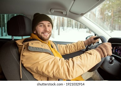 Happy Young Active Man In Warm Winterwear Looking At You With Toothy Smile While Sitting By Steer And Driving To His Country House