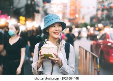 Happy Young Adult Asian Foodie Woman Backpack Traveler Eating Coconut Juice. People Traveling With Lifestyle Outdoor At China Town Street Food Market. Bangkok, Thailand