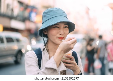 Happy Young Adult Asian Foodie Woman Backpack Traveller Eating Asia Dessert. People Traveling With New Normal Lifestyle At Outdoor At China Town Street Food Market. Bangkok, Thailand