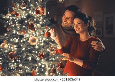 A happy young adult couple in love in an affectionate embrace, celebrating Christmas and decorating the Christmas tree. - Powered by Shutterstock