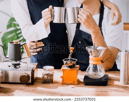 Happy young adult couple making breakfast and drinking coffee together in cozy home kitchen in morning at home. Preparing meal and smiling. Lifestyle, leisure and Love concept.