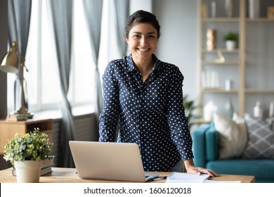 Happy Young Adult Indian Woman Student Freelancer Teacher Look At Camera Stand At Home Office Table With Laptop Computer, Online Study Concept, Easy E Learning In Internet, Education Software Tech