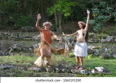 Happy Young Adult Male And Female  Polynesian Pacific Islanders Couple Dancing Together On An Ancient Maori Marae In The Highlands Of Rarotonga, Cook Islands. Real People. Copy Space