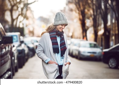 Happy Young Adult Woman Walking At Beautiful Autumn City Street Wearing Colorful Scarf And Warm Hat.
