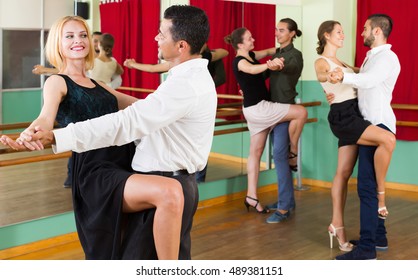 Happy Young Adults Having Tango Class At Dance Studio. Selective Focus
