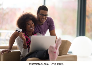 Happy Young African American Couple Shopping Online Through Laptop Using Credit Card At Home