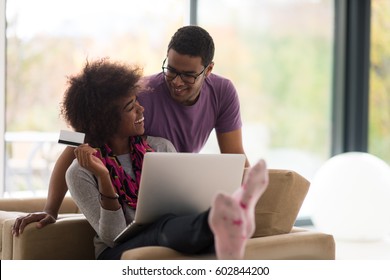 Happy Young African American Couple Shopping Online Through Laptop Using Credit Card At Home