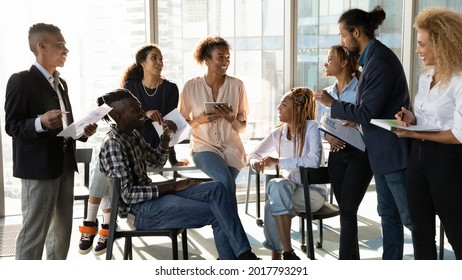Happy young african american female leader holding negotiations meeting with friendly diverse colleagues gathered at table in modern office room, discussing project ideas or developing strategy. - Shutterstock ID 2017793291