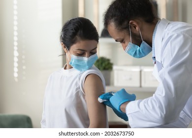 Happy Young African American Male General Practitioner Doctor Making Anti Covid Injection To Indian Ethnic Woman. Smiling Mixed Race Diverse Therapist And Patient Involved In Vaccination Process.