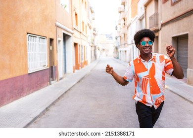 Happy young African American man dancing in the street celebrating and enjoying life. Having fun. Copy space. - Shutterstock ID 2151388171