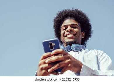 Happy young african american man using smartphone and smiling - Powered by Shutterstock