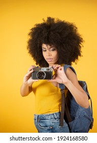 A Happy Young African American Photographer Holding Retro Fil Yellow Background