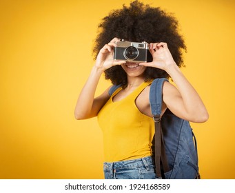 A Happy Young African American Photographer Holding Retro Fil Yellow Background