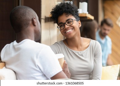 Happy young african american woman smiling enjoy fun conversation with man friend boyfriend, mixed race teen girl in love talk laughing flirting at meeting, black couple on first date outdoor concept - Powered by Shutterstock