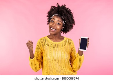 Happy Young African American Woman Holding Mobile Phone In Hand, Excited About A Text Message Or A Notification About Winning A Contest