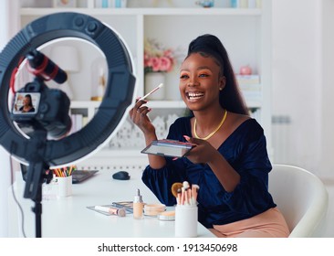 happy young african american woman streaming a beauty vlog from home, online content creator applying a makeup on - Shutterstock ID 1913450698