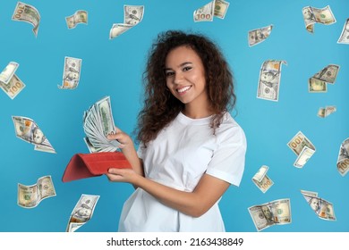 Happy Young African American Woman With Money And Falling American Dollars On Turquoise Background